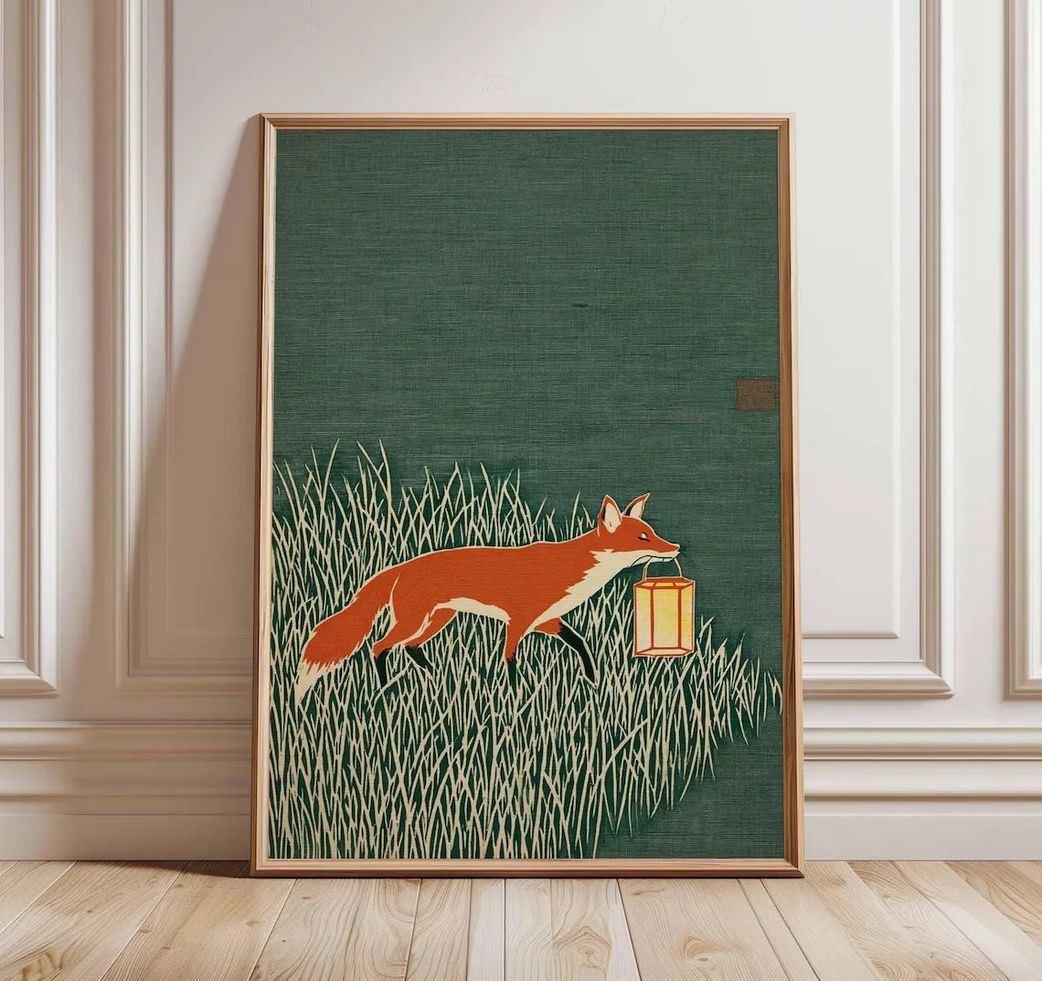 Minimalist Japanese-inspired fox art print showing an orange fox carrying a lantern through tall grass against a deep green background in a natural wood frame.