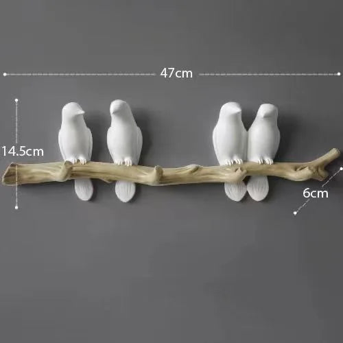 Decorative wall art with white birds on a branch against a dark background