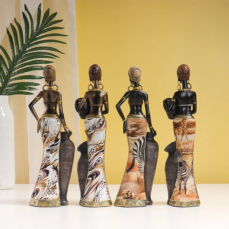 Four decorative figurines with patterned designs on a white surface against a yellow wall.