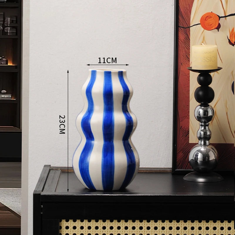 Blue and white striped vase on a table with measurements indicated