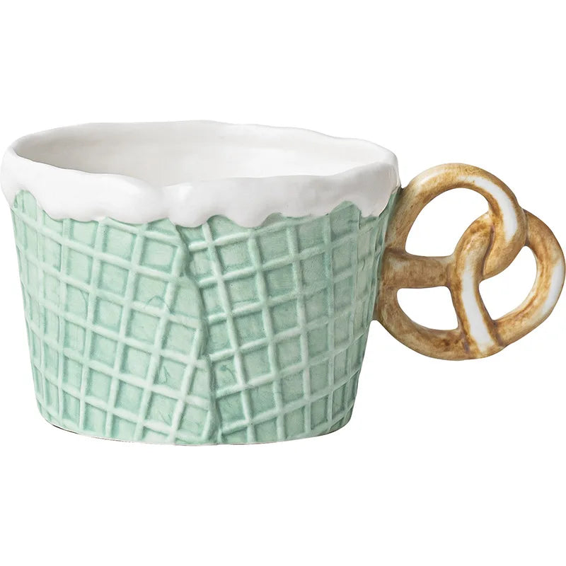 Mint green mug with a pretzel-shaped handle on a white background