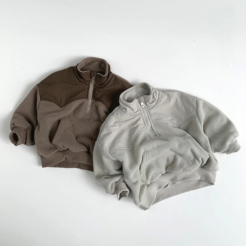 Two fleece pullovers, one brown and one gray, on a white background