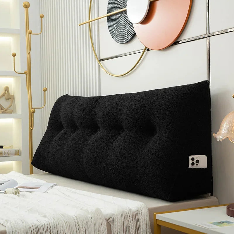 Black tufted headboard pillow on a bed in a stylish bedroom setting.