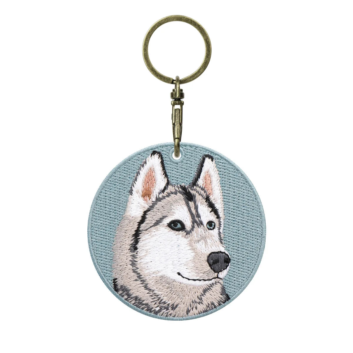 Keychain with embroidered design of a husky dog face on a light blue background