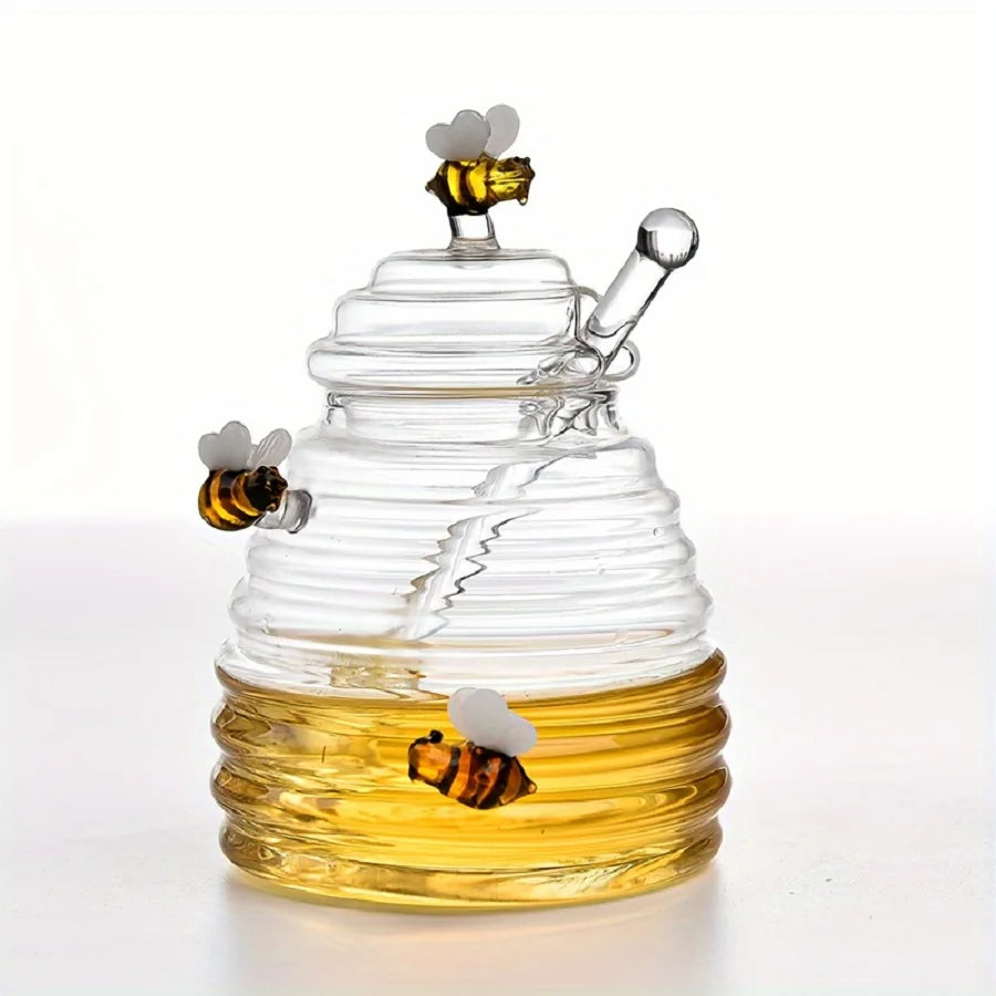 Glass honeycomb with honey and bee decorations on a white background