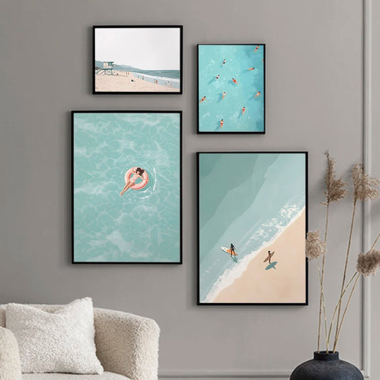 Four framed beach-themed artworks on a gray wall above a sofa.