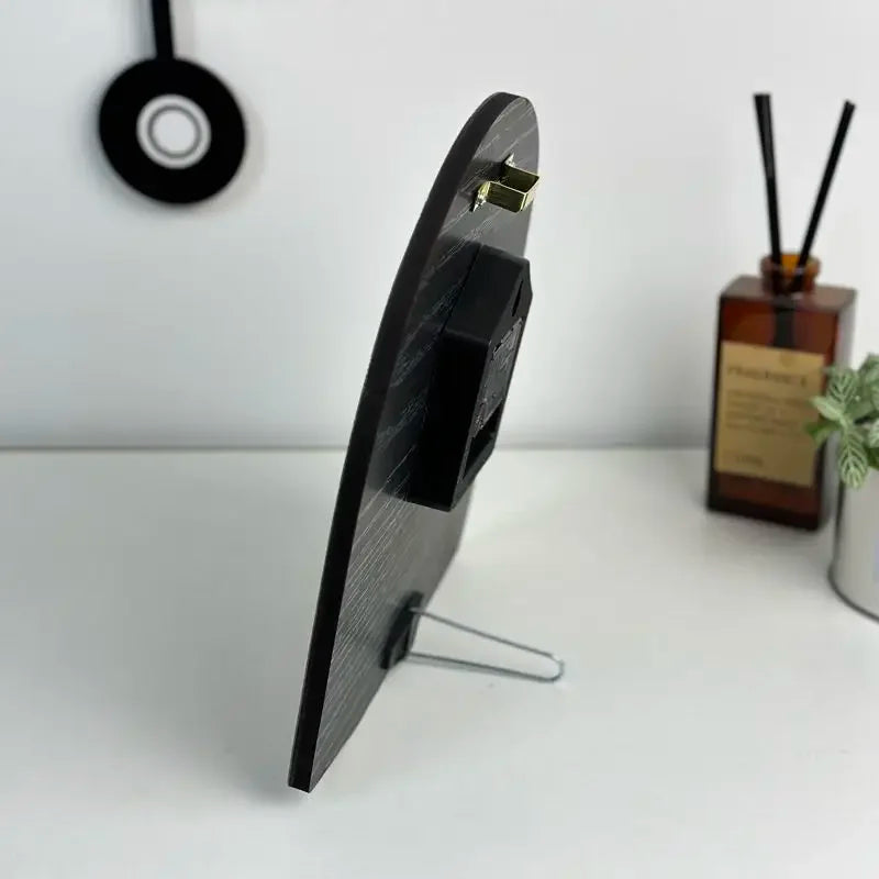 Black rectangular object on a stand with a white background