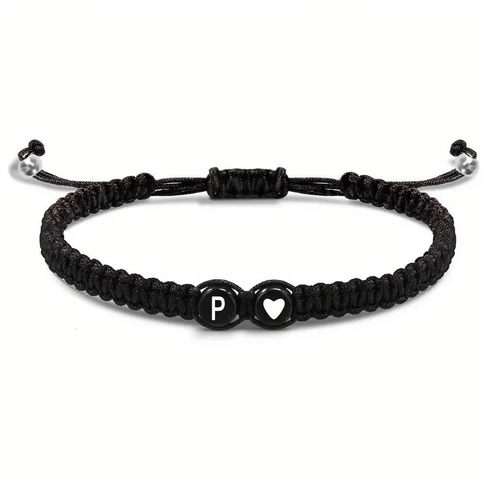 Black braided bracelet with letter 'P' and heart charm on a white background