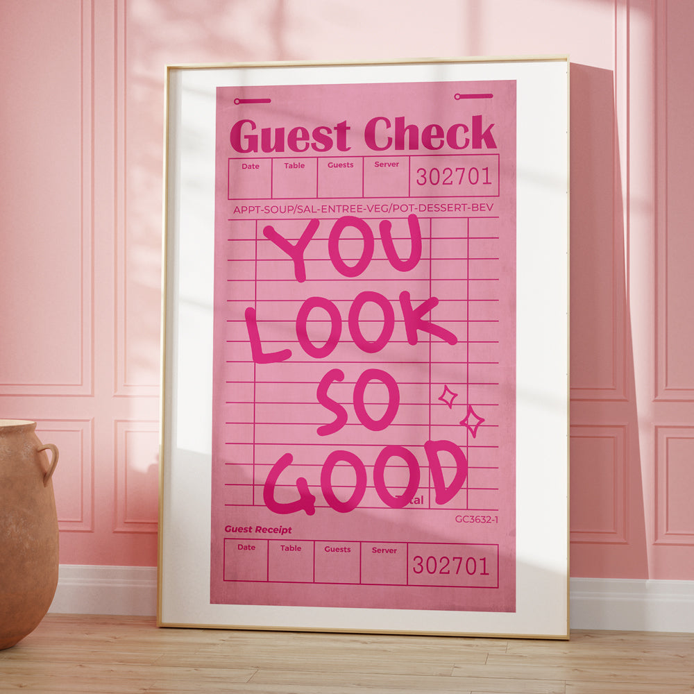 Framed pink sign with 'You Look So Good' text on a pink wall.