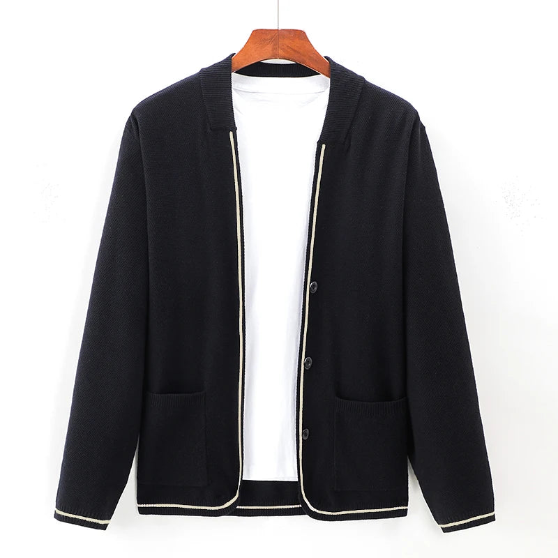 Black cardigan on a hanger against a white background