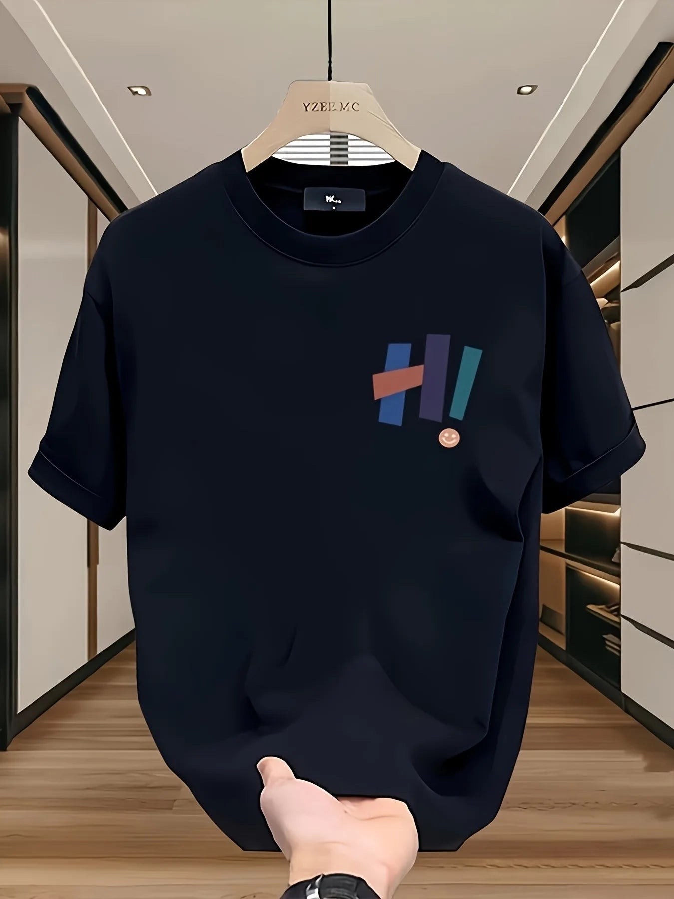 Black t-shirt with colorful design on a hanger