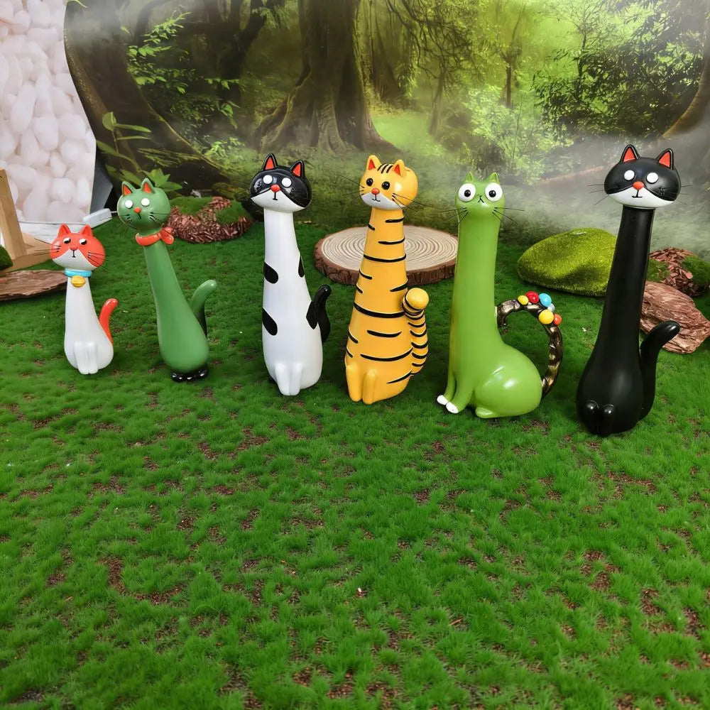 Set of colorful cat-shaped garden stakes on grass with a forest background
