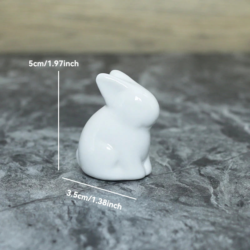 White ceramic rabbit figurine with measurements on a textured surface