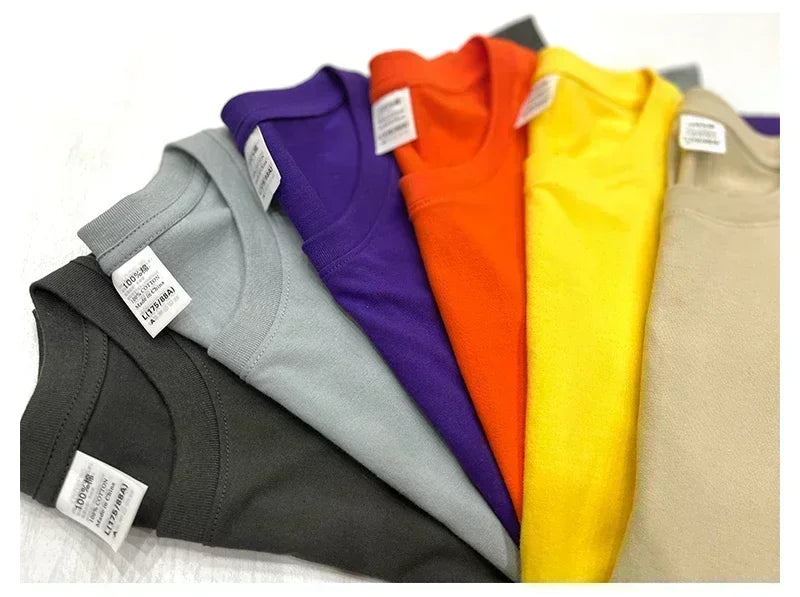 Folded t-shirts in various colors with labels on a white background
