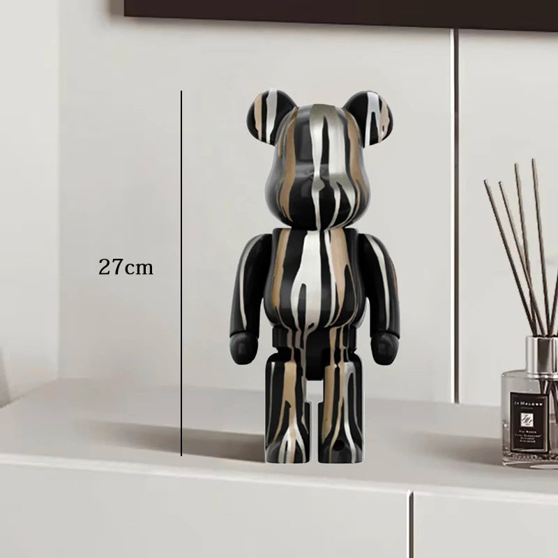 Black and white striped bear figure on a white surface with a measurement label