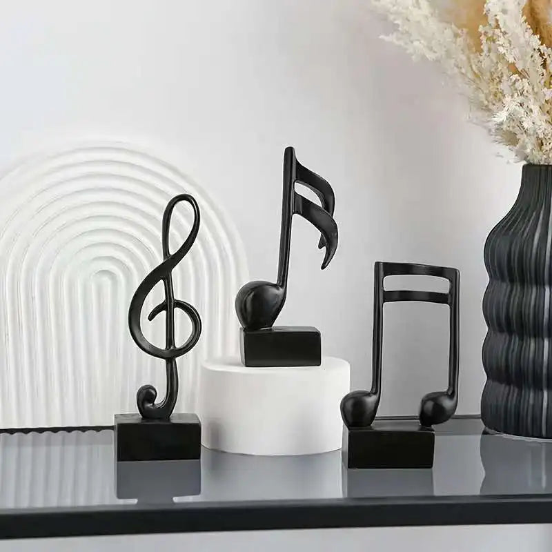 Set of three modern resin musical note sculptures with black bases displayed as contemporary home décor, available in black, white and gold finishes.