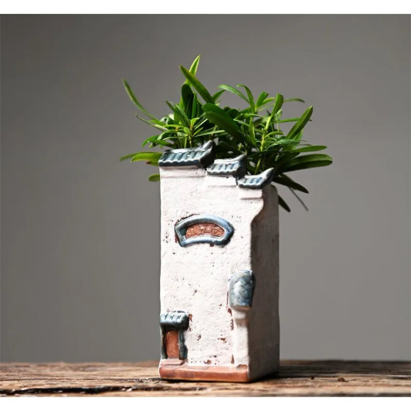 Decorative ceramic planter with a plant on a wooden surface and gray background