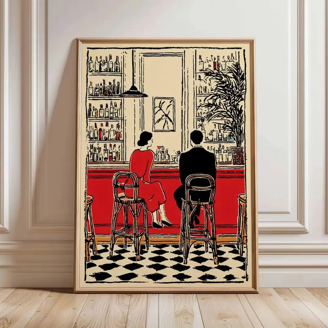 A framed art print depicting a retro bar scene with a woman in a red dress and a man in a black suit sitting at the counter, leaning against a white paneled wall on a light wood floor.