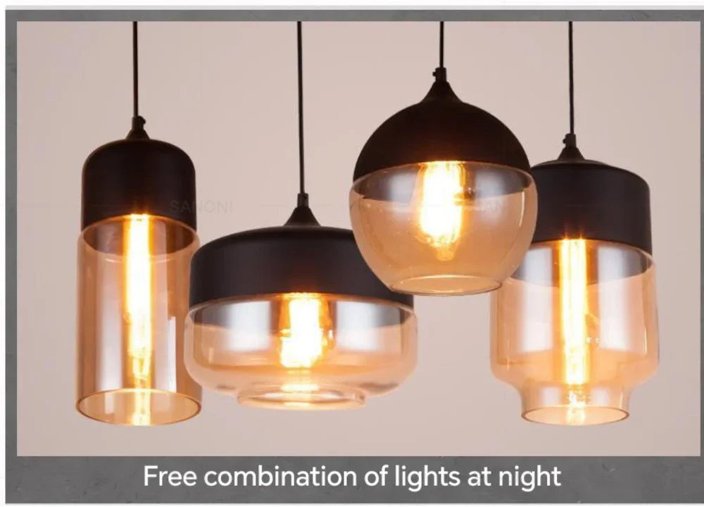 Set of pendant lights with glass shades and black metal fixtures on a neutral background.