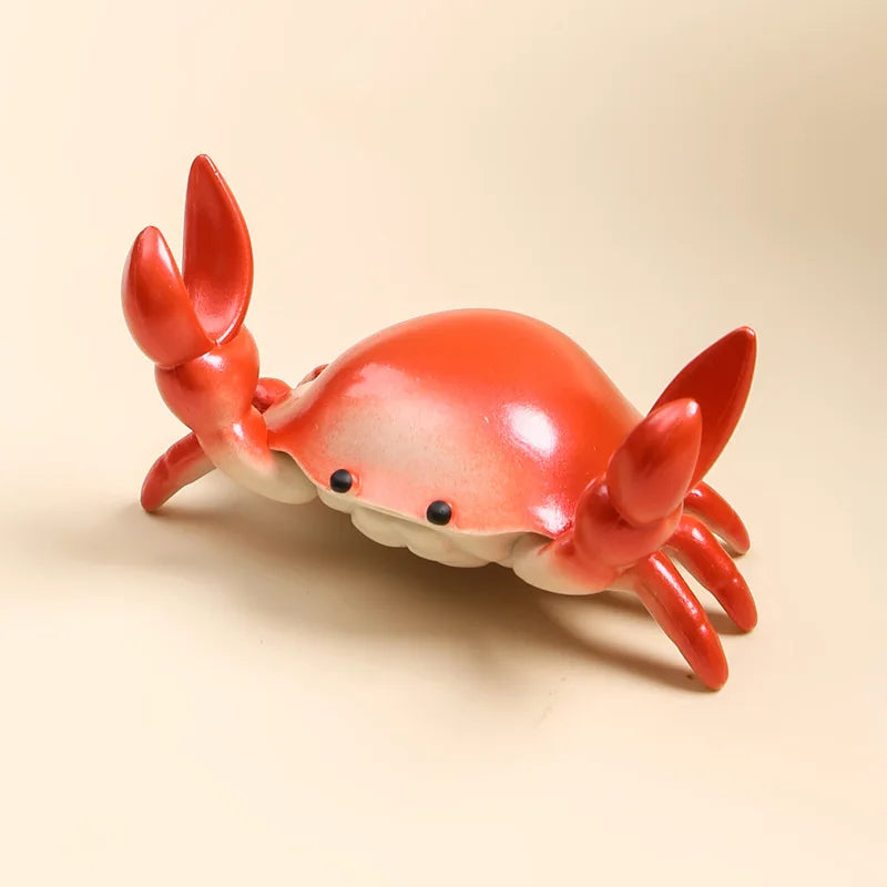 Red crab-shaped desktop organiser on a beige background