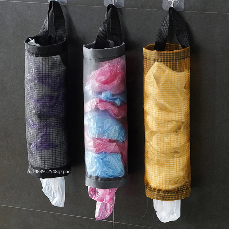 Three hanging trash bags with clear covers on a dark tiled wall.