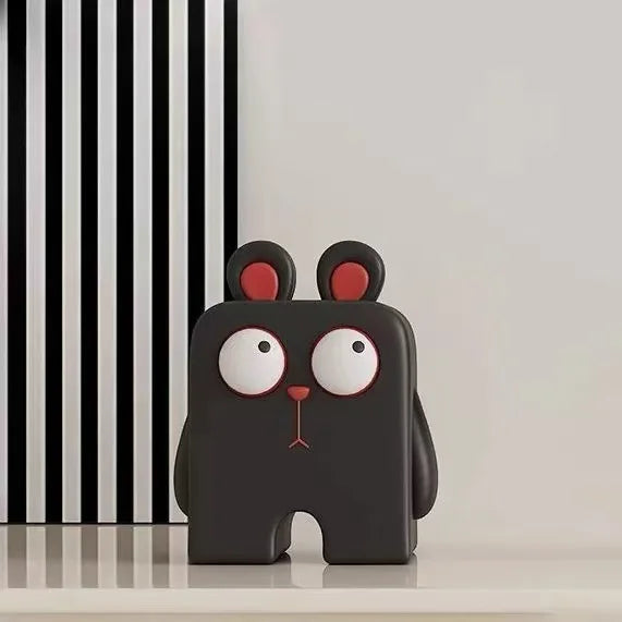 Black cartoon-like figure with red ears and white eyes against a black and white striped background