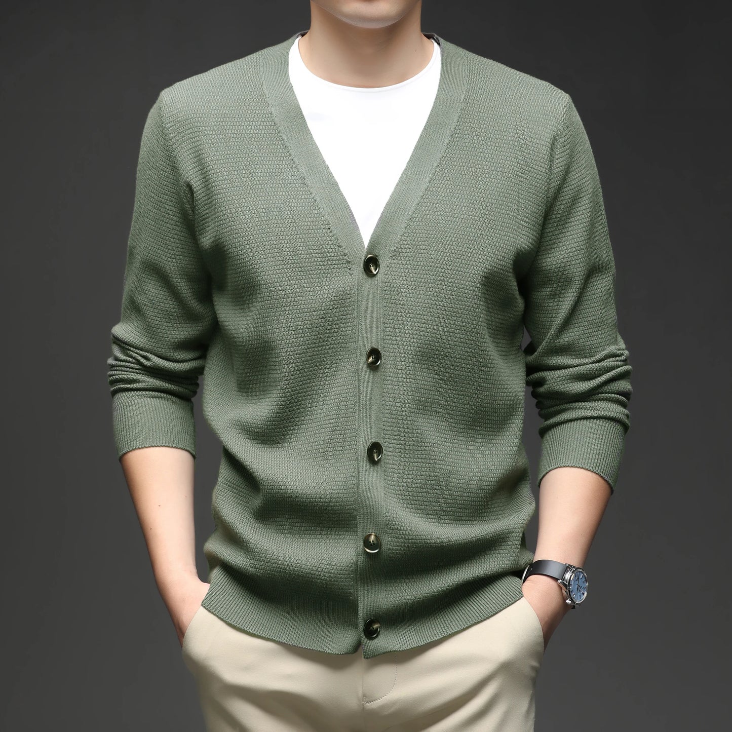 Green cardigan worn by a person on a dark background