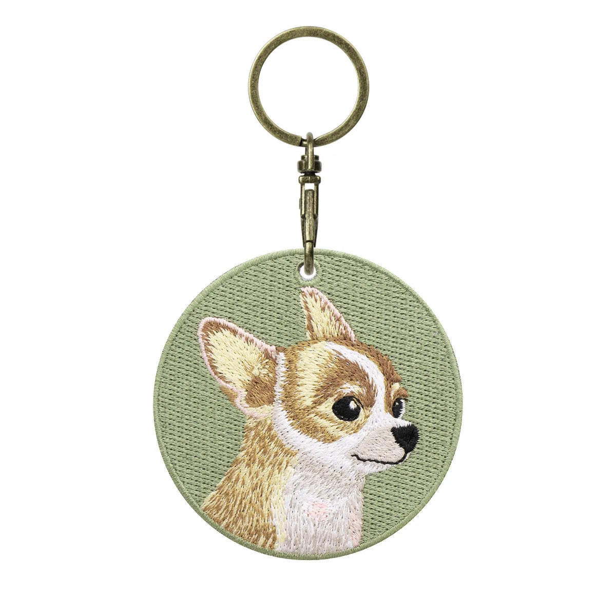 Circular keychain with embroidered dog design on a light green background