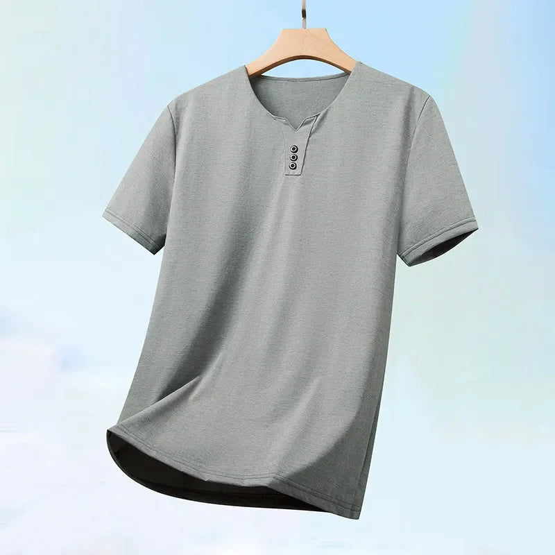 Gray t-shirt with button details on a hanger against a light blue background