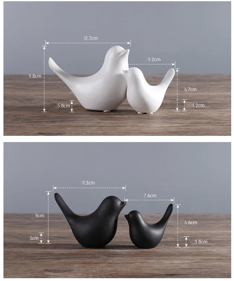White and black ceramic bird figurines with measurements on a wooden surface.