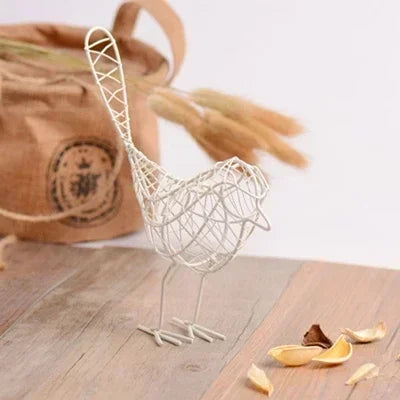 Wire bird sculpture on a wooden surface with a blurred background