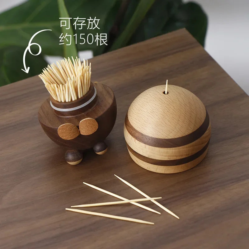 Two handcrafted wooden bee toothpick holders with striped natural wood finish displayed on a wooden tabletop as decorative kitchen accessories.