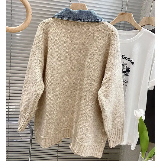 Beige sweater with denim collar on a hanger against a neutral background