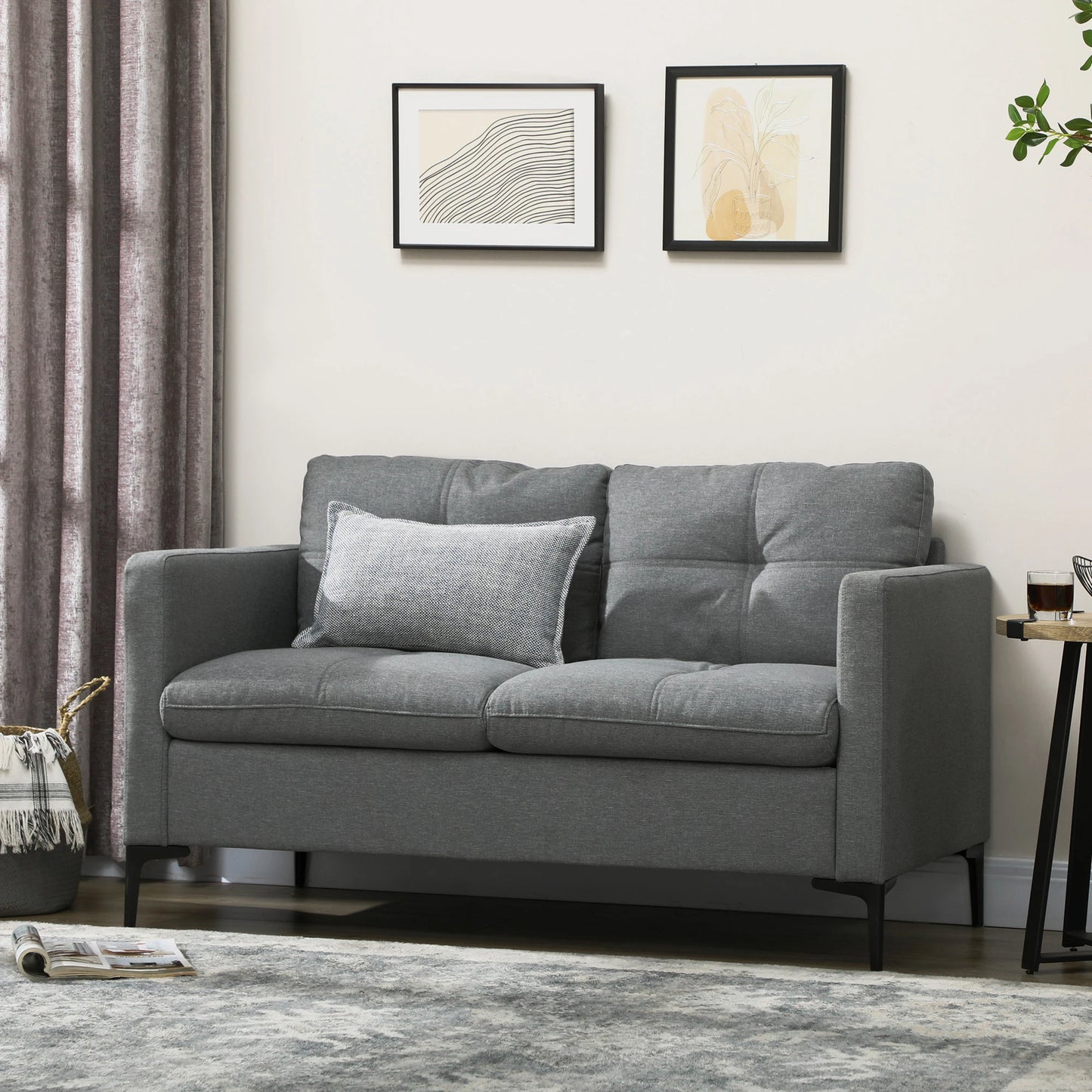 Gray sofa in a living room with framed artwork on the wall.