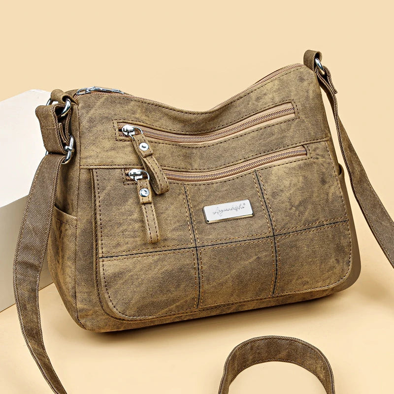 Brown  handbag with multiple zippers on a beige background