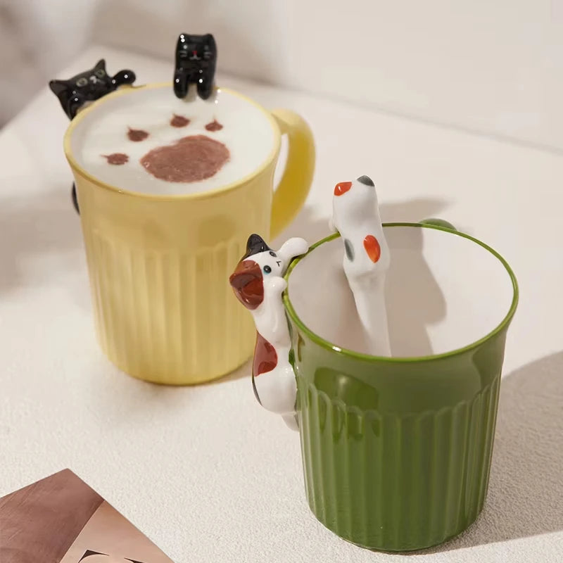 Green and yellow ceramic cat mugs with a 3D cat climbing over the rim.