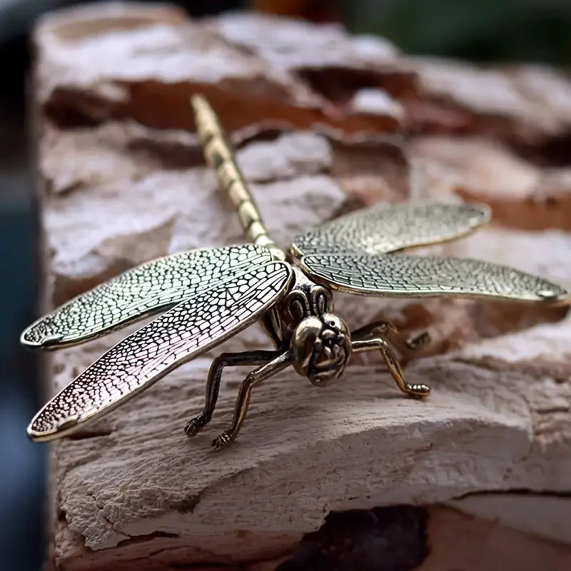 Bronze dragonfly-shaped hairpin on a textured surface
