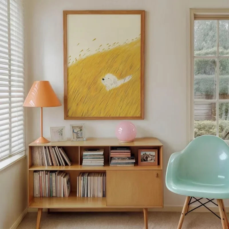 Vintage style dog art prints featuring cozy reading dogs and painterly animal illustrations displayed in a wooden frame on a wall above a sidebaord