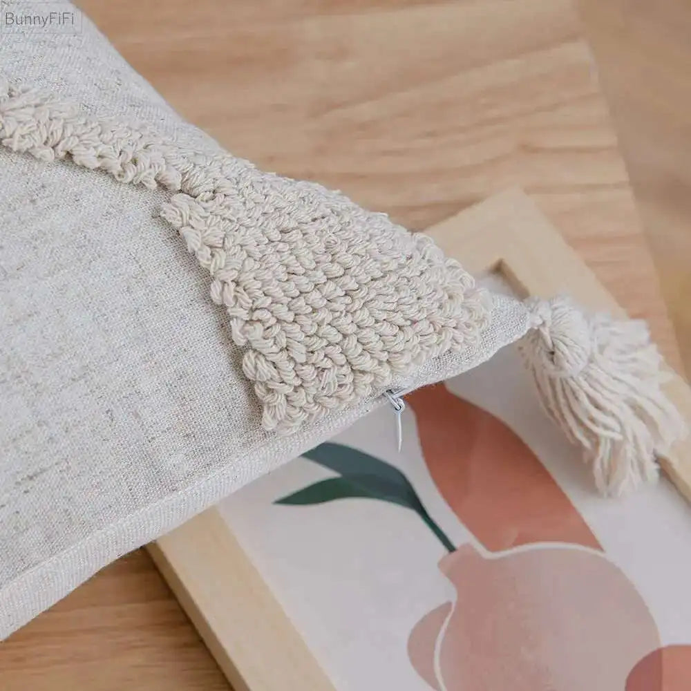 Textured fabric with tassels draped over a wooden frame with a floral design.