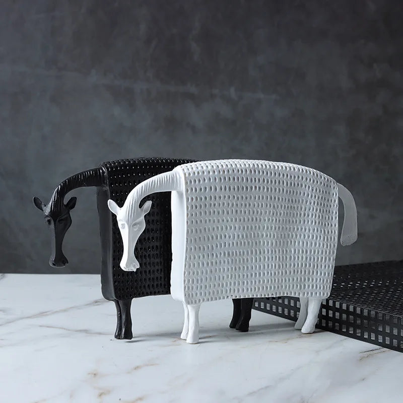 Two animal-shaped stools, one black and one white, on a marble surface with a dark gray background.