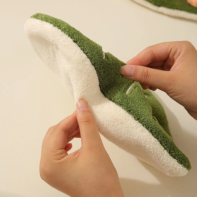 Green and white hand towel held by a hand against a neutral background