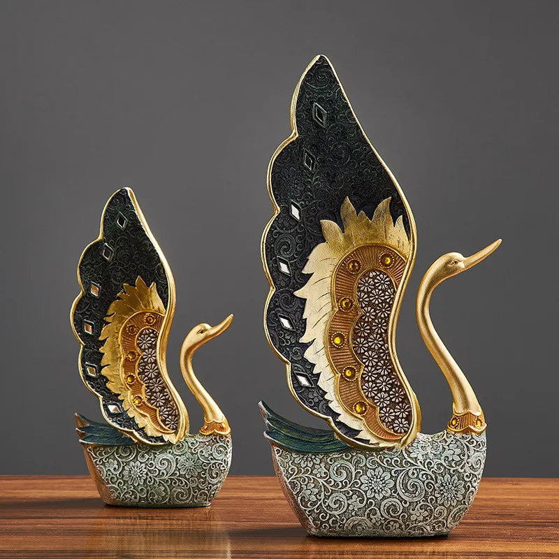 Decorative swan sculptures with intricate designs on a wooden surface and dark background