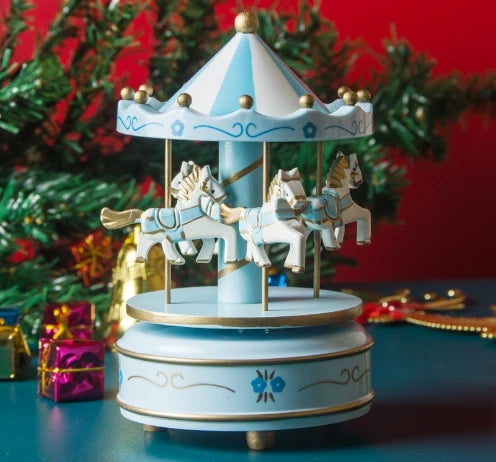 Decorative carousel with horses on a blue base against a festive background with Christmas trees and presents.