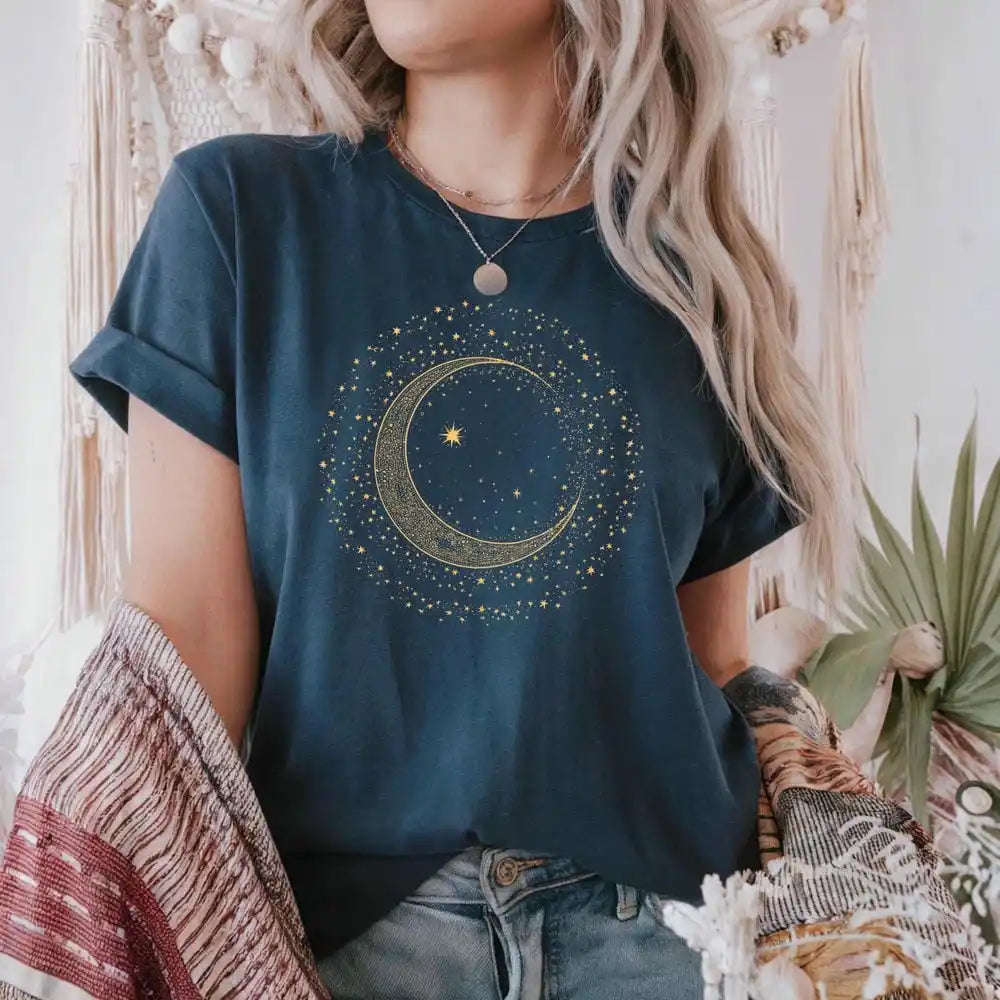 Person wearing a dark blue t-shirt with a celestial design, standing in a decorative indoor setting.