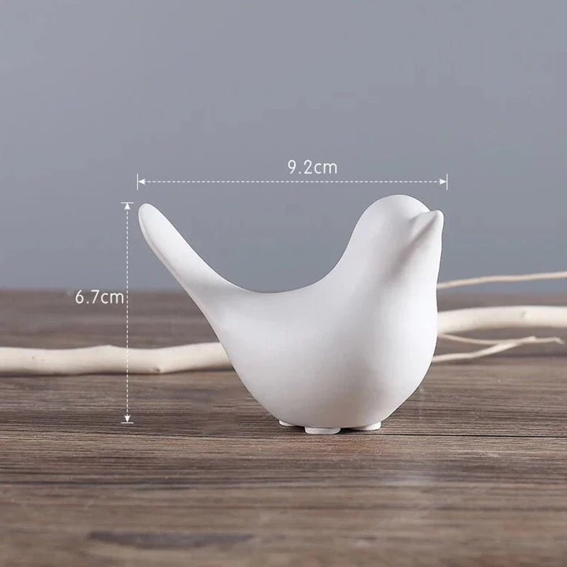 White ceramic bird figurine with measurements on a wooden surface and gray background