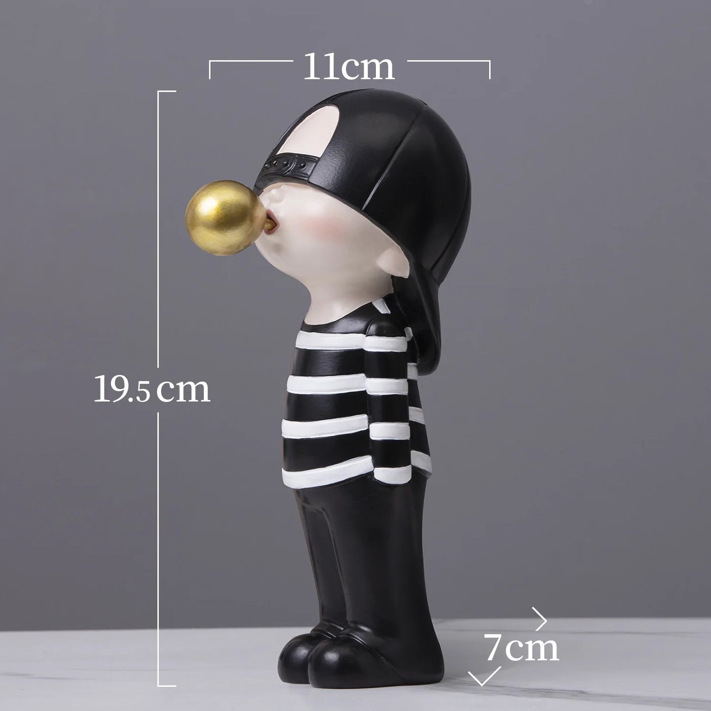 Decorative figurine of a child blowing a bubble with measurements on a gray background
