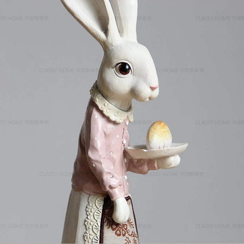 Decorative rabbit figurine holding a plate with an egg against a gray background