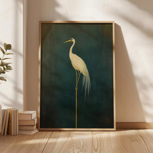 Framed artwork of a crane on a dark green background, leaning against a wall with natural light casting shadows.