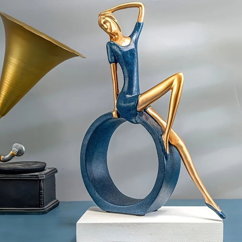 Artistic sculpture of a woman with a gold horn and blue dress, with a vintage record player in the background.