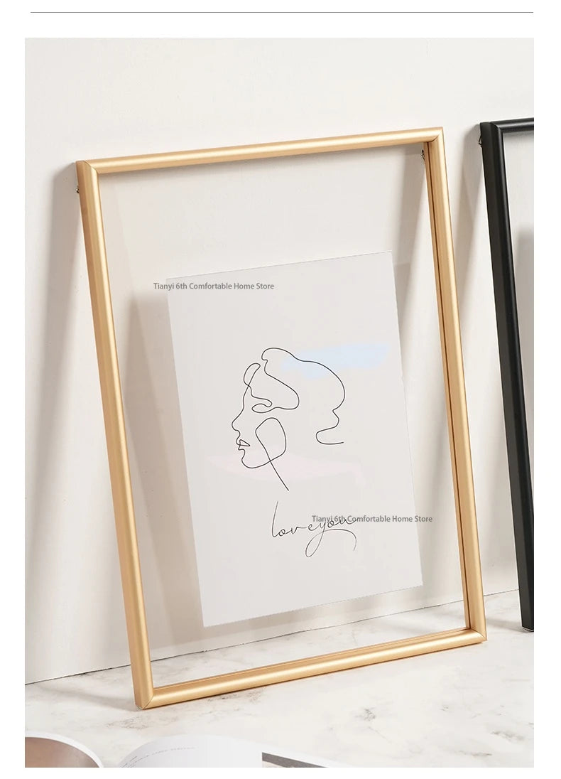 Gold-framed artwork with a minimalist line drawing of a face on a white background